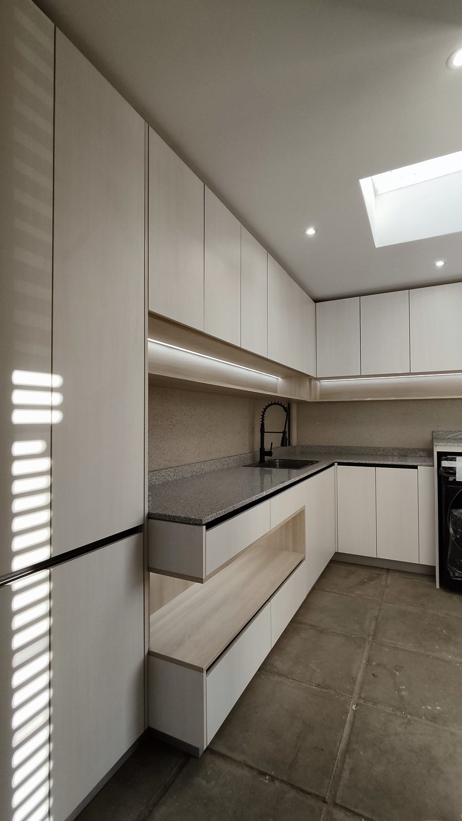 Logia con muebles blancos a medida y encimera de granito
