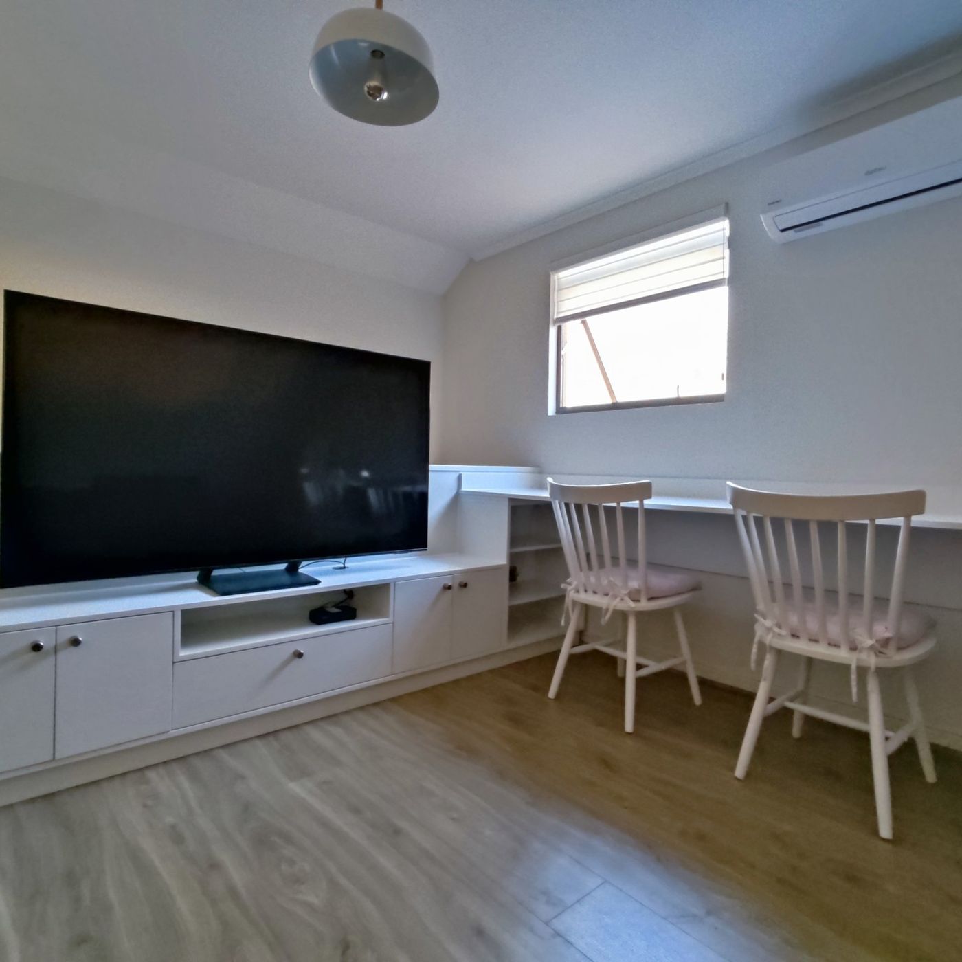 Home office y muebles a medida bajo techo inclinado